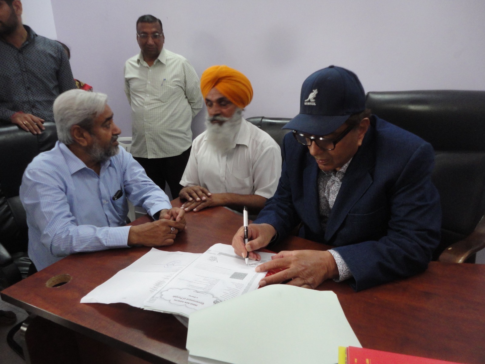Dharmendra signing a gift deed of his land in favour of cousins Shingara Singh and Manjit Singh in 2015.