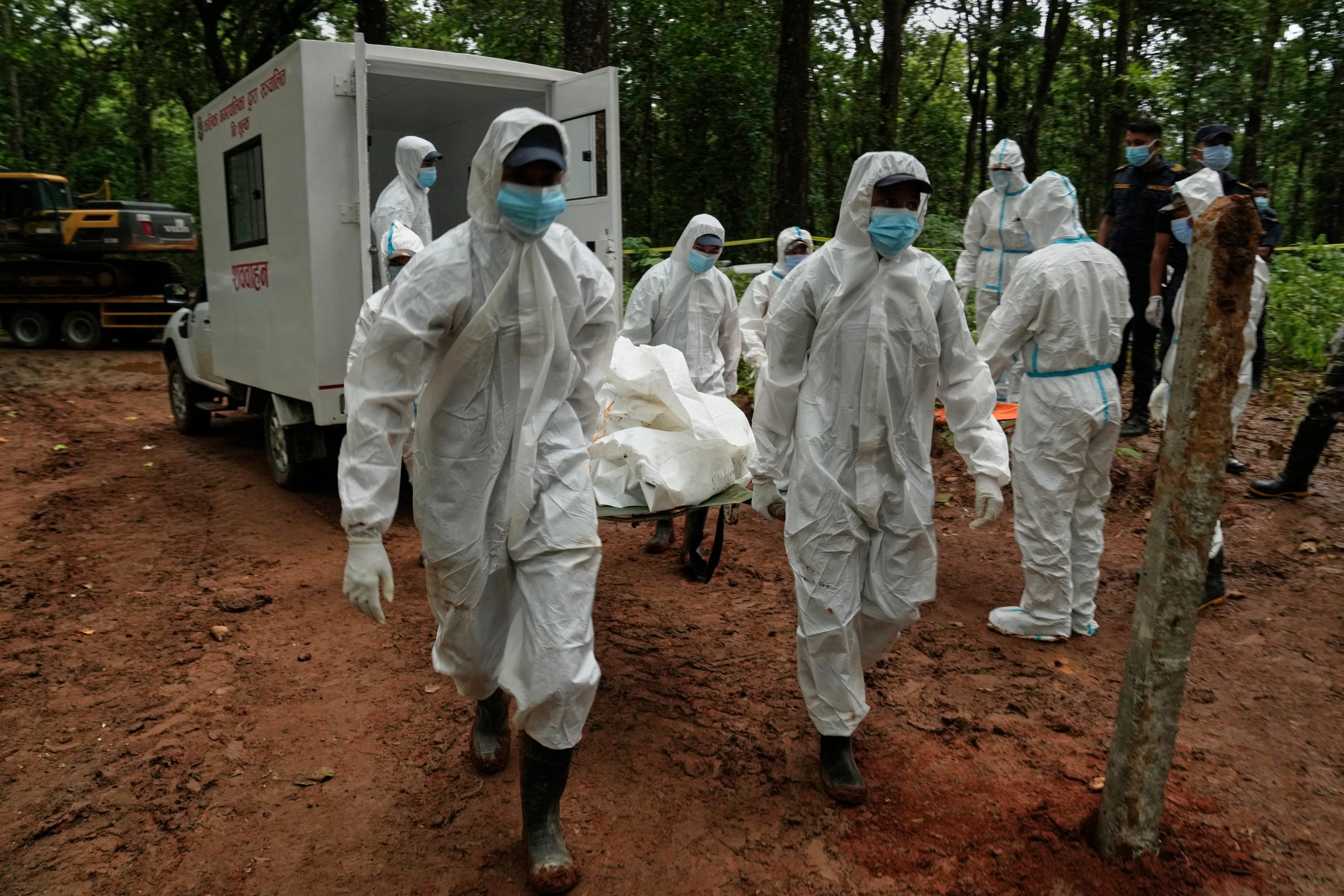 Nepal begins temporary burial of unidentified flood victims as bodies begin to decompose